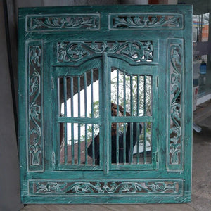 Hand-carved teal Balinese wood window frame with intricate floral detailing