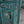 Green hand-carved Balinese wooden door panel with intricate floral patterns