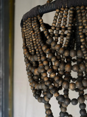 Handcrafted wooden beaded chandelier with natural rustic finish, close-up view