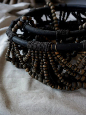 Hand-carved Balinese wooden bead chandelier on fabric, artisanal rustic home decor