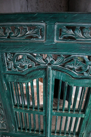 Hand-carved green Balinese wood door with intricate floral and geometric patterns
