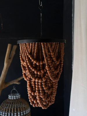 Handcrafted wood bead chandelier with natural finish, hanging in a minimalist room