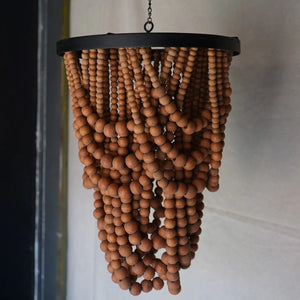 Handmade wooden beaded chandelier with natural finish hanging from ceiling