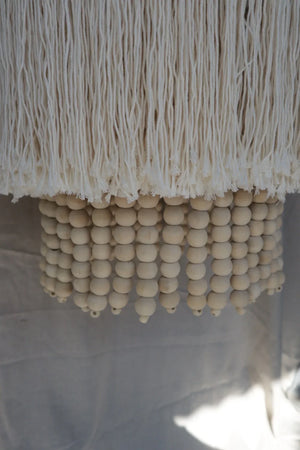 Handmade Balinese chandelier with natural wooden beads and cream tassels