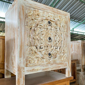 Hand-carved wooden nightstand with intricate floral patterns and rustic whitewash finish