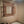 Hand-carved Balinese wood mirror with window shutters in a beige bathroom