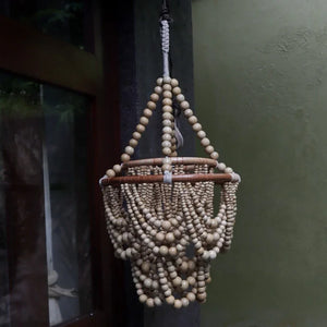 Handcrafted Balinese beaded chandelier with natural wooden beads, boho home decor accent.